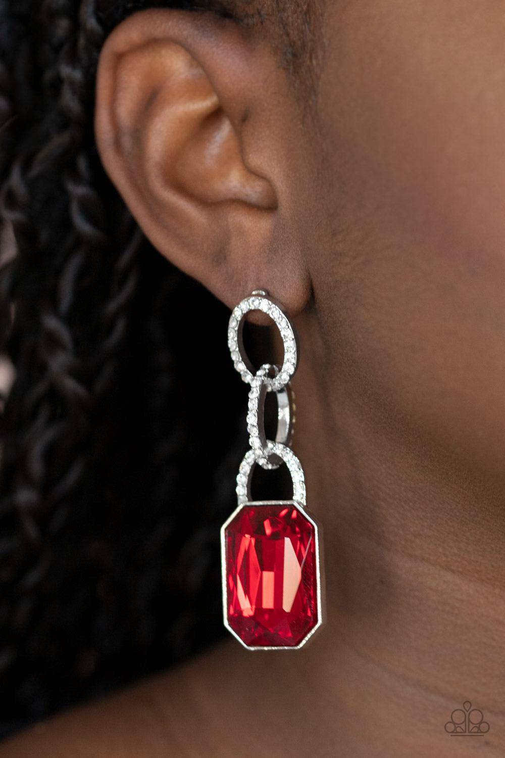 Paparazzi Accessories Superstar Status - Red An oversized red emerald-cut rhinestone swings from the bottom of white rhinestone encrusted links, creating a gorgeously dramatic lure. Earring attaches to a standard post fitting. Sold as one pair of post ear