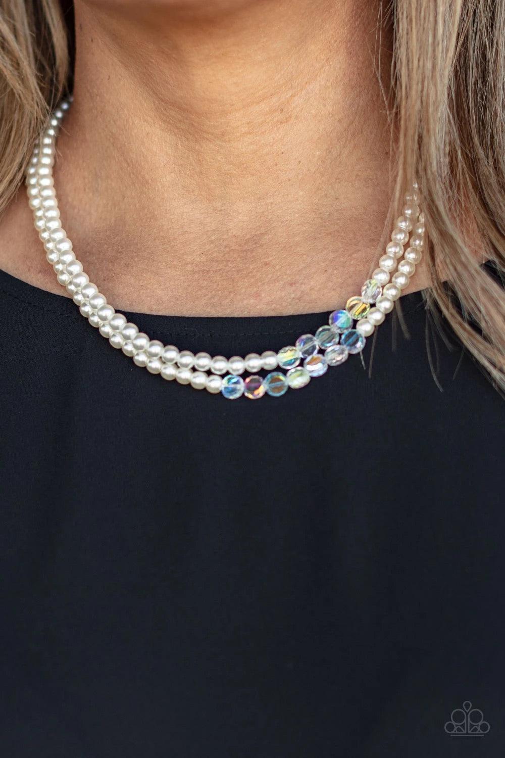 Paparazzi Accessories Poshly Petite - White A posh collection of pearly white beads, accented by sections of flat faceted shimmery clear beads, is threaded along invisible wires, creating sophisticated layers that fall below the collar. Features an adjust