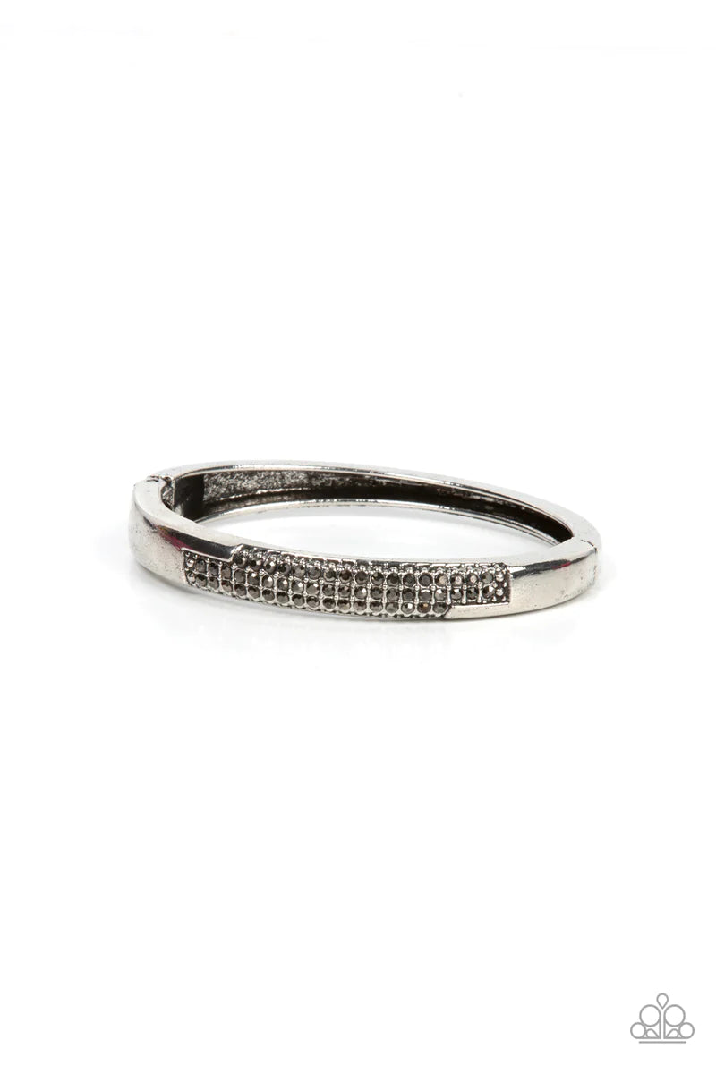 Paparazzi Accessories Chart-Topping Twinkle - Silver The front of a silver frame is chiseled away, revealing two rows of glitzy hematite rhinestones across the center of a gritty bangle-like bracelet. Features a hinged closure. Sold as one individual brac