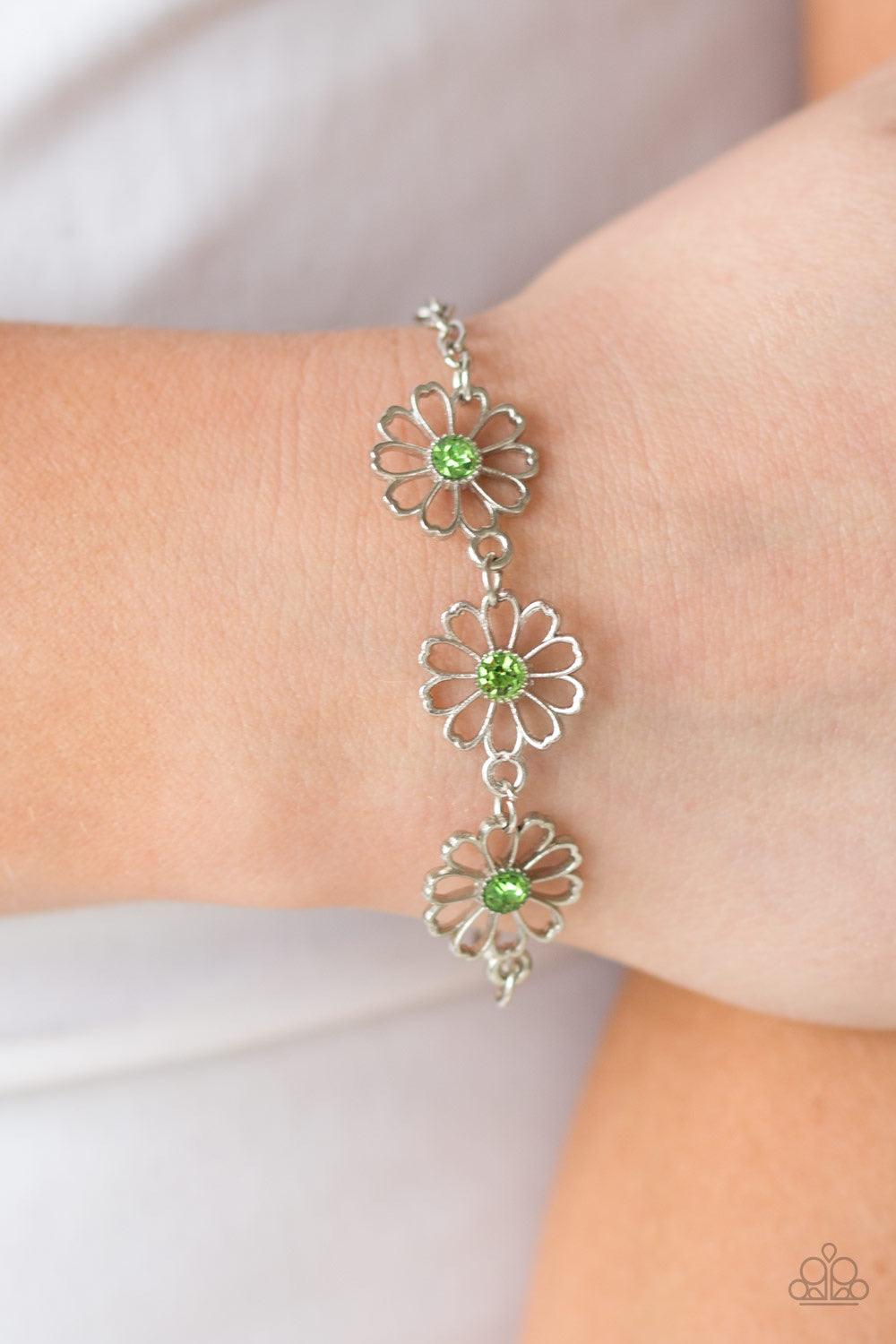 Paparazzi Accessories Dancing Daffodils - Green Stenciled silver floral charms link around the wrist. Glittery green rhinestones dot the dainty floral centers, adding a whimsical finish to the airy palette. Features an adjustable clasp closure. Sold as on