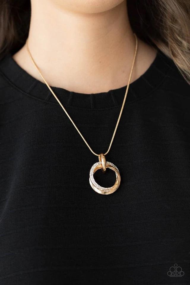 Paparazzi Accessories Sphere of Influence - Gold A solid gold ring entwines with a brilliant white rhinestone encrusted ring. The pair of rings rest in a gold hoop on a short round gold chain. Features an adjustable clasp closure. Sold as one individual n
