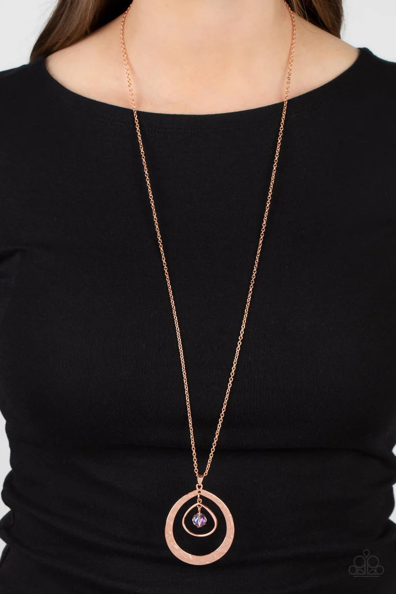 Paparazzi Accessories Tasteful Teardrops - Copper An iridescent peach crystal-like bead twinkles from the top of two mismatched shiny copper teardrop frames at the bottom of an extended shiny copper chain, resulting in a tasteful and timeless pendant. Fea