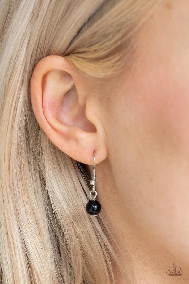 Paparazzi Accessories Impressive Edge - Black Featuring a triangular shape, a shiny black bead is pressed into a hammered silver teardrop radiating with airy cut-out patterns for an edgy look. The impressive pendant swings from the bottom of a lengthened