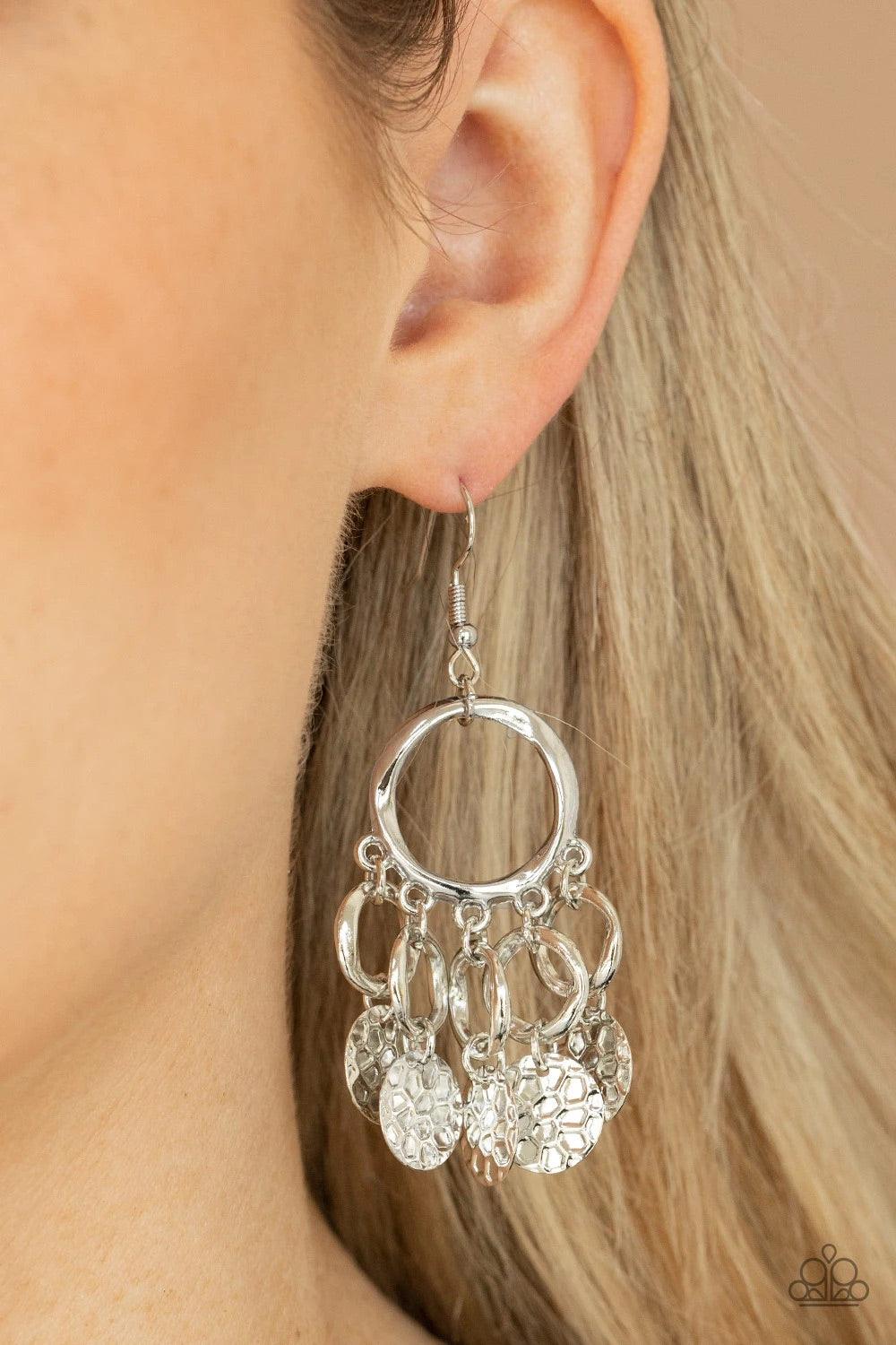 Paparazzi Accessories Partners in CHIME - Silver Embossed in tactile geometric patterns, shiny silver discs swing from the bottom of dainty silver rings at the bottom of an asymmetrical silver ring for a noise-making fashion. Earring attaches to a standar