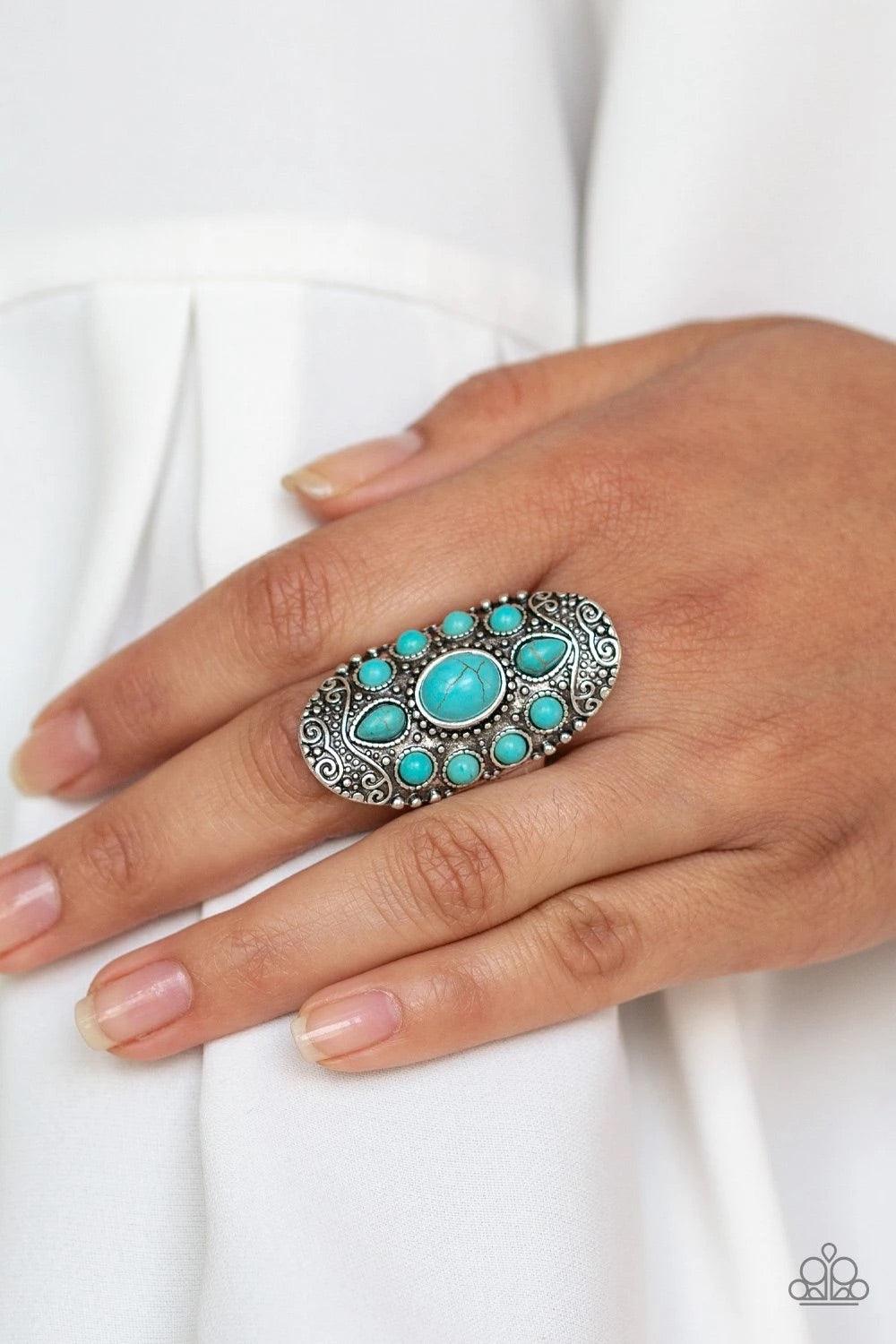 Paparazzi Accessories Stone Sunrise - Blue Embossed in a studded filigree pattern, an oval silver frame folds around the finger. Featuring round, oval, and teardrop shapes, refreshing turquoise stone beads are pressed into the center of the frame, creatin