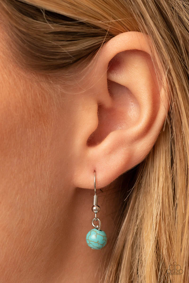 Paparazzi Accessories Winslow Wanderer - Blue Strips of brown leather fan out from the bottom of a round turquoise stone that is threaded along a metal rod that attaches to the bottom of a silver horseshoe frame. The earthy pendant swings from the bottom