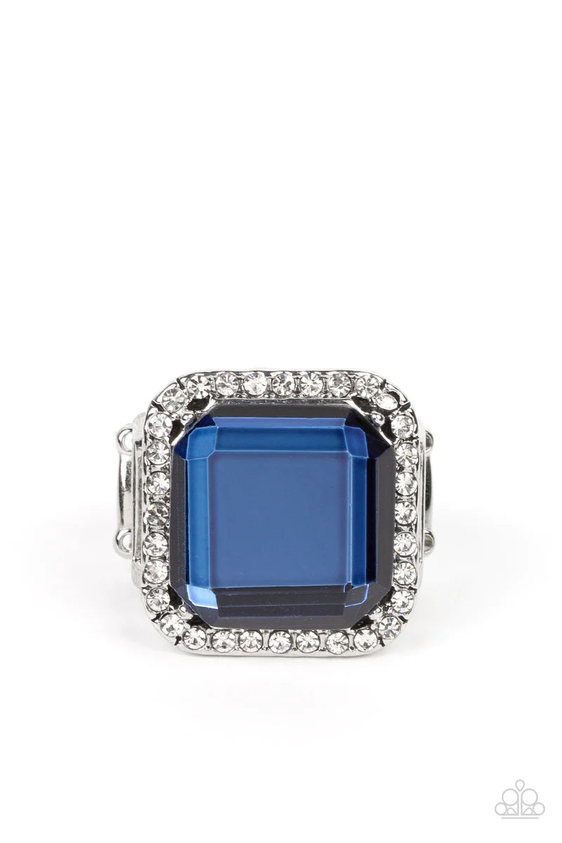 Paparazzi Accessories Slow Burn - Blue A lavish square Skydiver gem, encased in a border of dainty white rhinestones, makes a head-turning centerpiece as it gleams with an industrial edge atop the finger. Features a stretchy band for a flexible fit. Sold