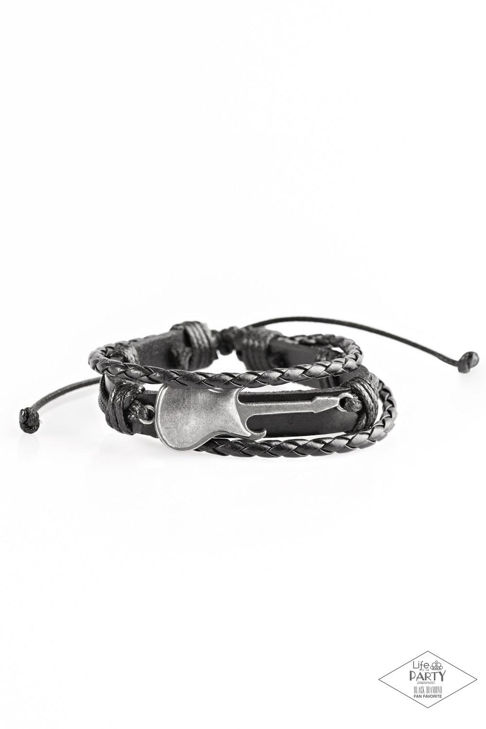 Paparazzi Accessories Lead Guitar - Black Two strands of braided leather cording join a rustic black leather band around the wrist. Shiny black cording wraps around a metallic guitar charm, knotting the centerpiece in place for an urban finish. Features a