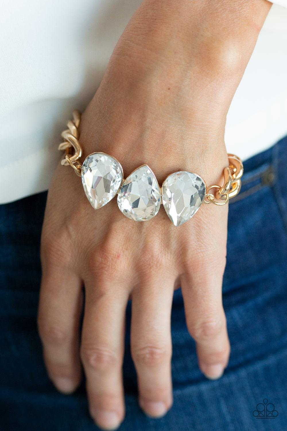 Paparazzi Accessories Bring Your Own Bling - Gold Three oversized white teardrop gems join at the center of a dramatic gold chain, creating a jaw-dropping display across the wrist. Features an adjustable clasp closure. Jewelry