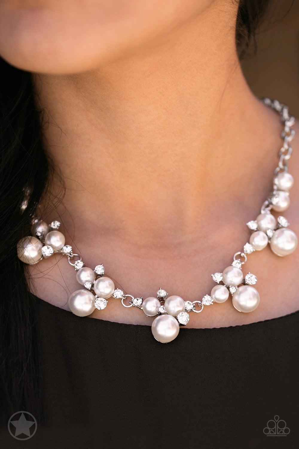 Paparazzi Accessories Toast To Perfection - White Clusters of pearls and dazzling white rhinestones join below the collar, creating refined frames. Infused with a glistening silver chain, the sections of luminescent frames trickle along the neck in a time