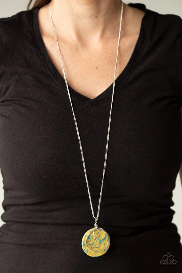 Paparazzi Accessories Sahara Equinox - Yellow Featuring a faux stone finish, an earthy yellow frame swings behind two shimmery silver rings at the bottom of a lengthened silver chain, creating a colorfully stacked pendant. Features an adjustable clasp clo