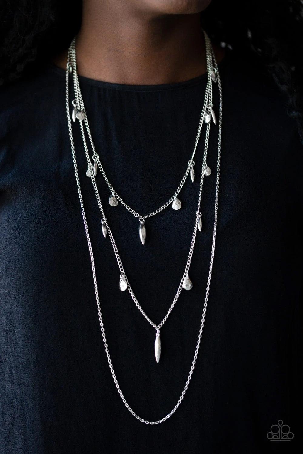 Paparazzi Accessories Bravo Bravado - Silver Mismatched silver chains layer down the chest. Faceted silver teardrops and shiny silver accents swing from two of the shimmery silver chains for an edgy finish. Features an adjustable clasp closure. Sold as on