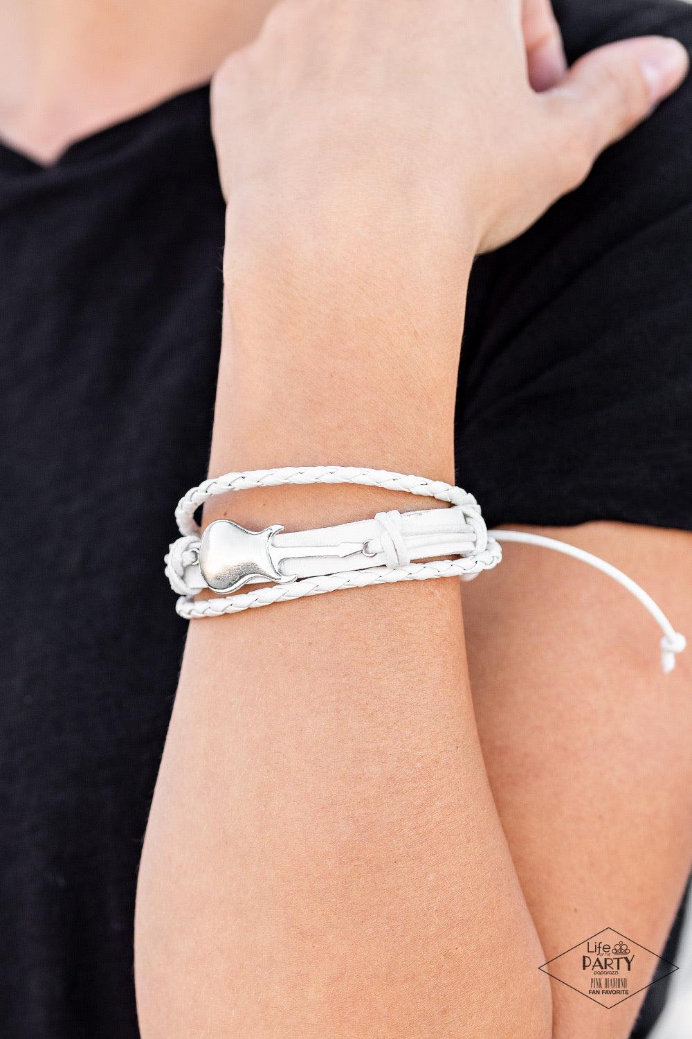 Paparazzi Accessories Lead Guitar ~White Two strands of braided leather cording join a rustic white leather band around the wrist. Shiny white cording wraps around a metallic guitar charm, knotting the centerpiece in place for an urban finish. Features an