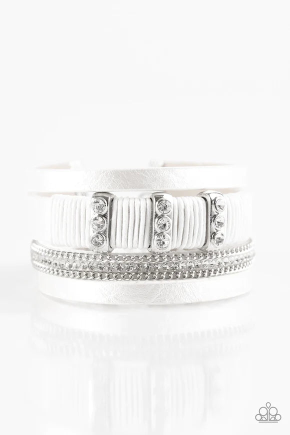 Paparazzi Accessories Frame Night - White Metallic white leather strands layer across the wrist. Infused with silver chain and white rhinestone accents, white cording knots around a leather strand, securing glittery white rhinestone frames in place for a