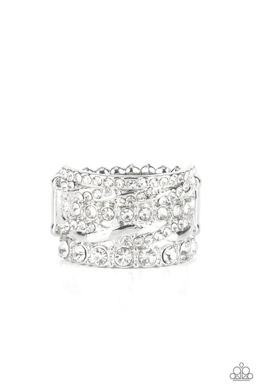 Paparazzi Accessories Exclusive Elegance - White Row after row of radiantly mismatched white rhinestones and glistening silver bands haphazardly stack across the finger, coalescing into a dramatic display of dazzle. Features a stretchy band for a flexible