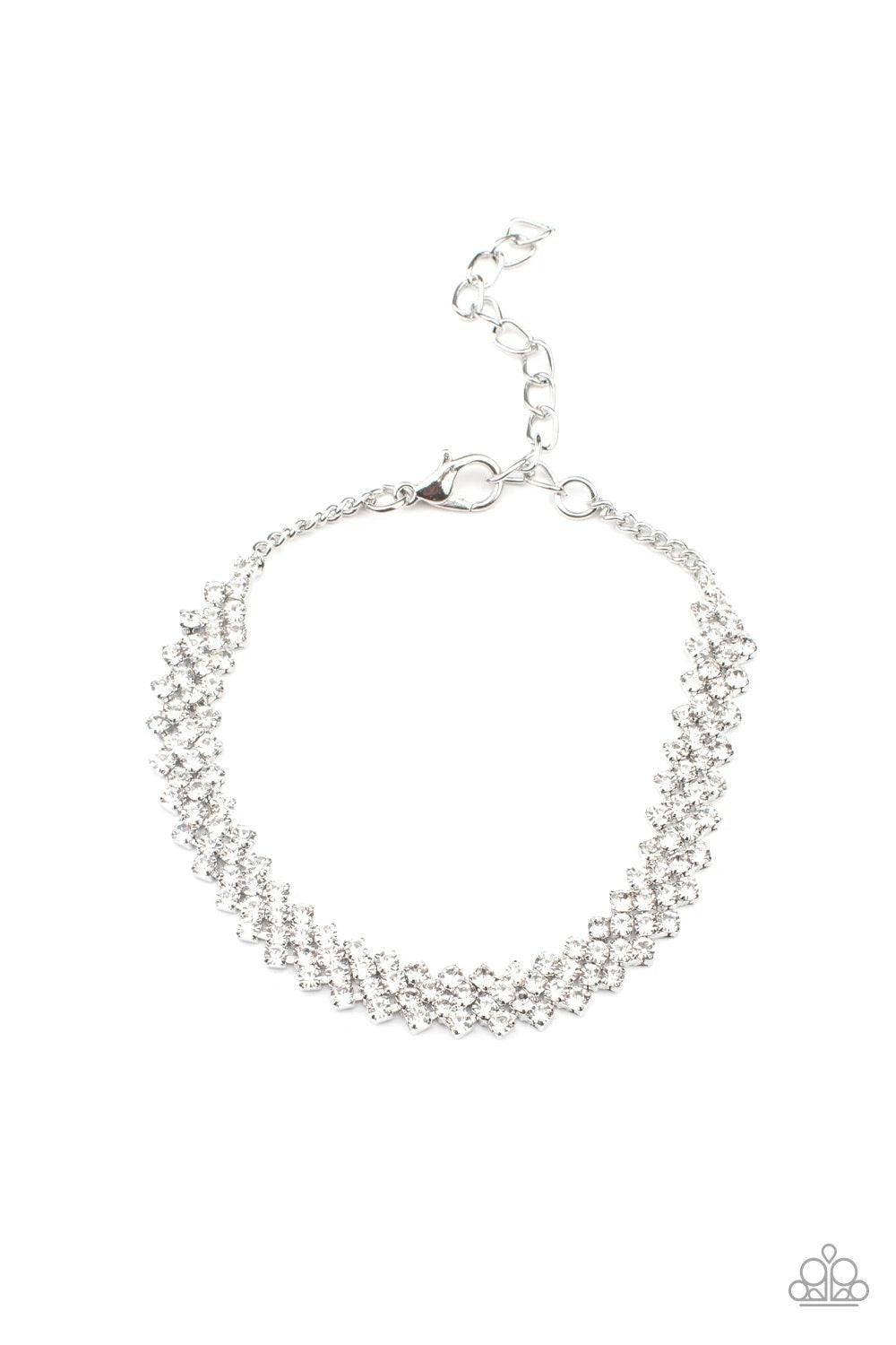 Paparazzi Accessories Chicly Candescent - White Featuring sleek silver fittings, dainty rows of glassy white rhinestones delicately slant across the wrist, coalescing into a timeless centerpiece. Features an adjustable clasp closure. Sold as one individua
