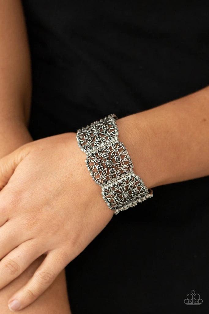 Paparazzi Accessories Enchanted Vineyard - Silver Ornately studded leafy filigree delicately gathers into airy silver square frames that are threaded along stretchy bands around the wrist, creating a vintage inspired look. Sold as one individual bracelet.