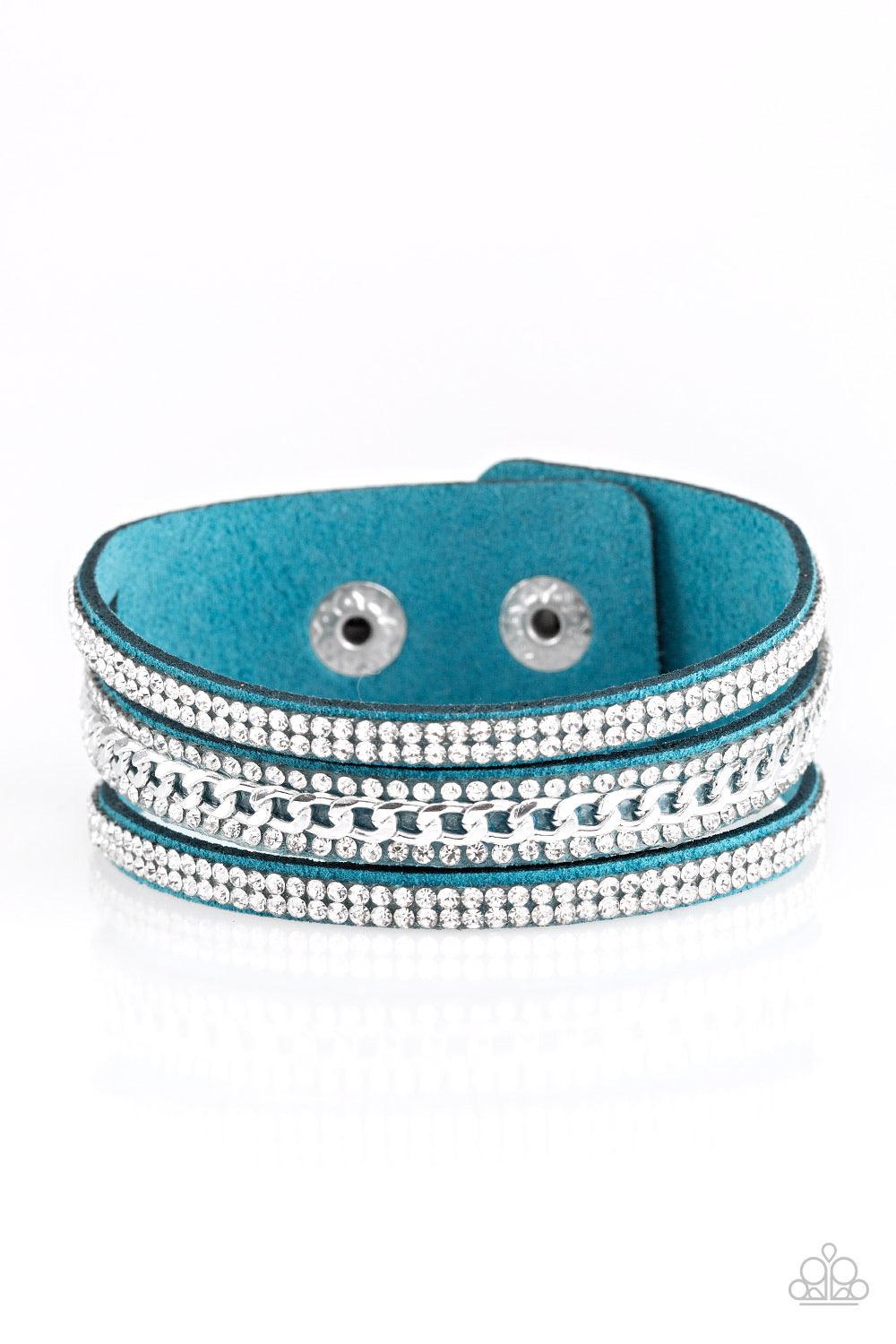 Paparazzi Accessories Rollin In Rhinestones - Blue Rows of glassy white rhinestones and a shimmery silver chain are encrusted along blue suede bands for a sassy look. Features an adjustable snap closure. Sold as one individual bracelet. Jewelry