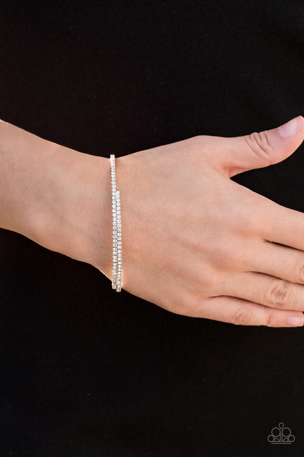Paparazzi Accessories Sleek Sparkle - White Dotted in dainty white rhinestones, a flexible wire coils around the wrist for a refined flair. Jewelry
