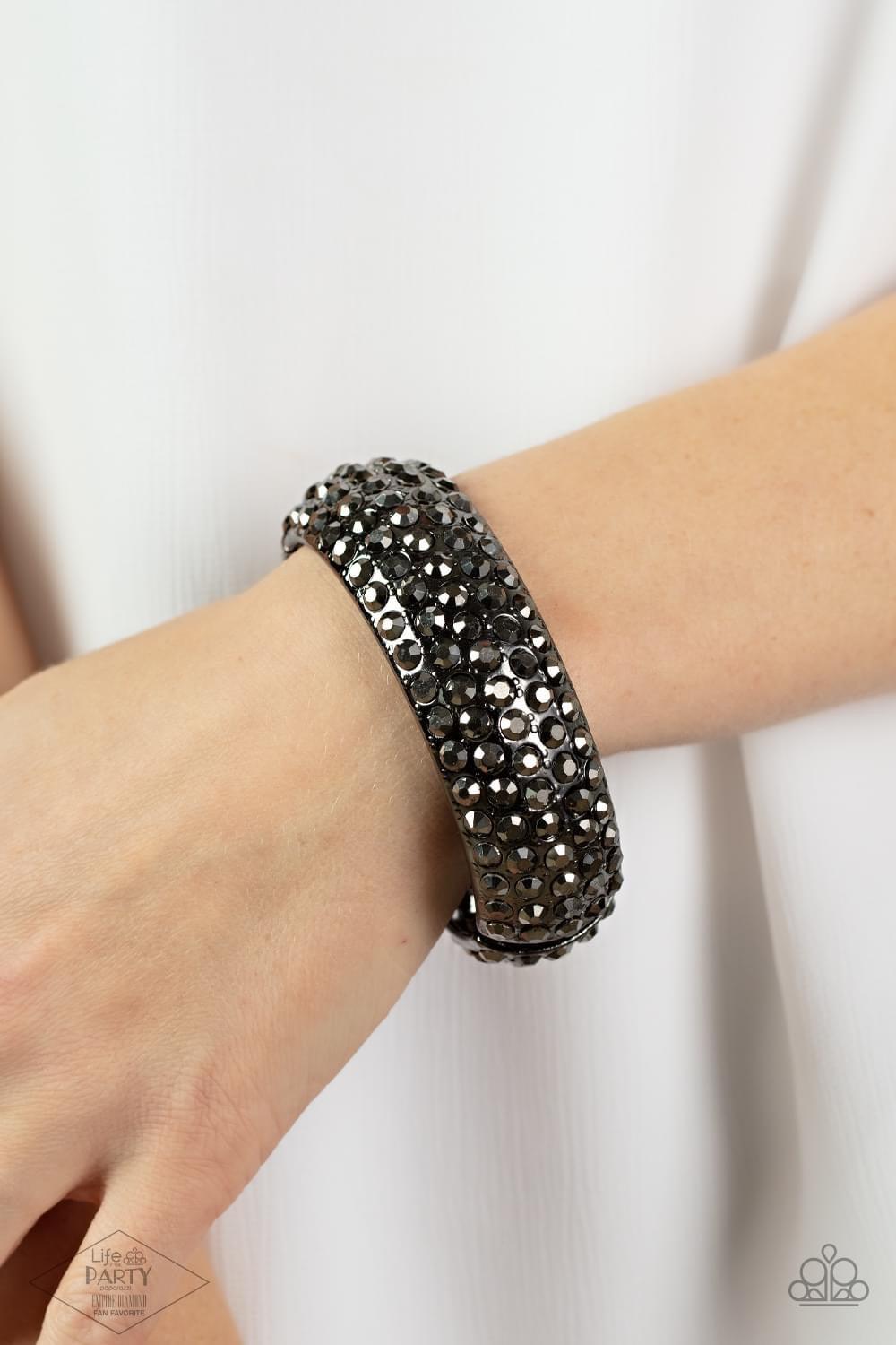 Paparazzi Accessories Making My Way Featuring a must-have hinged closure, the front of a thick gunmetal bangle is encrusted in row after row of smoky hematite rhinestones. The cuff-like bangle features a slight beveled surface, bringing the blinding spark