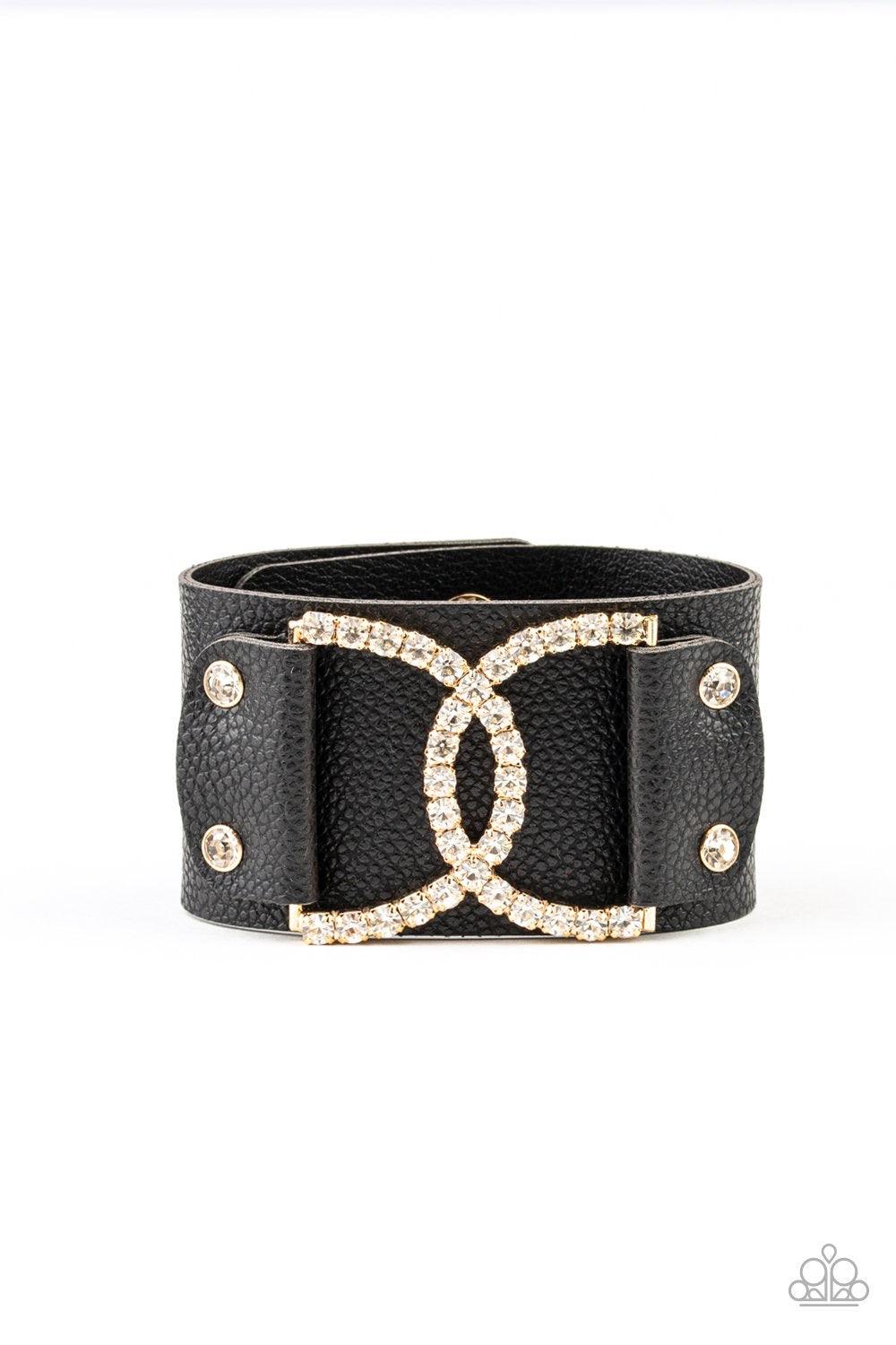 Paparazzi Accessories Couture Culture - Gold Encrusted in glassy white rhinestones, two interlocking half moon gold frames are studded in place across the front of a black leather band for a statement-making finish. Features an adjustable snap closure. So