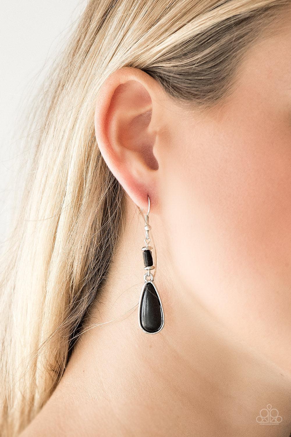 Paparazzi Accessories Courageously Canyon - Black Chiseled into a tranquil teardrop, an earthy black stone bead swings from the bottom stack of silver and stone beads, creating a seasonal lure. Earring attaches to a standard fishhook fitting. Sold as one
