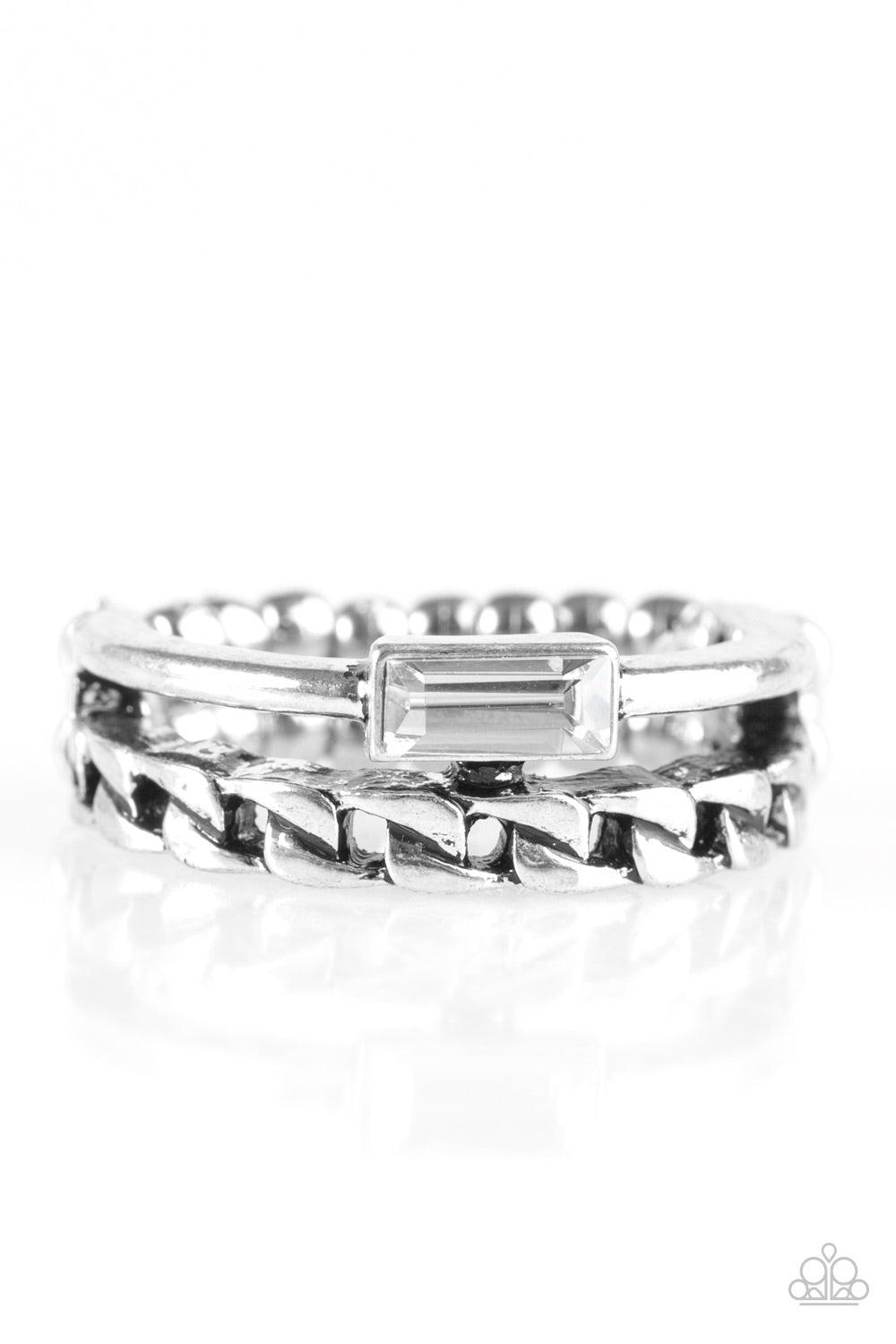 Paparazzi Accessories Edge Effect - Silver A smooth silver and chain-like band layer across the finger. Featuring an edgy emerald style cut, a glittery smoky rhinestone is pressed into the shiny silver band for a glittery finish. Features a dainty stretch