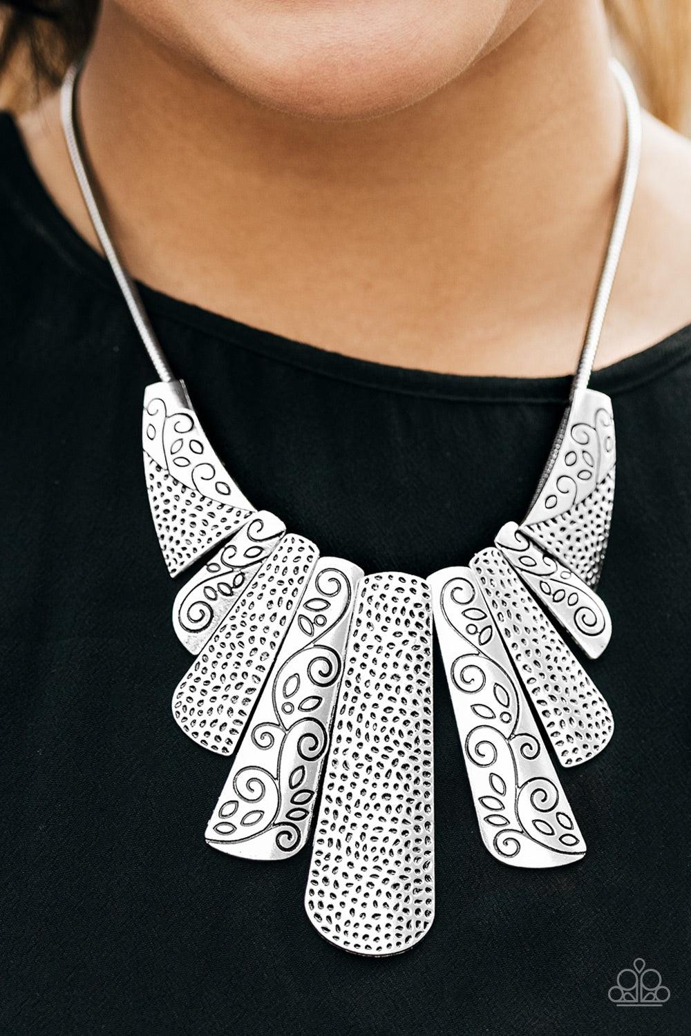 Paparazzi Accessories Untamed - Silver Silver plates featuring various hammered and filigreed textures fan out across the chest along a thick silver snake chain. The gorgeous tribal design falls gracefully below the collar into a dramatic statement piece.