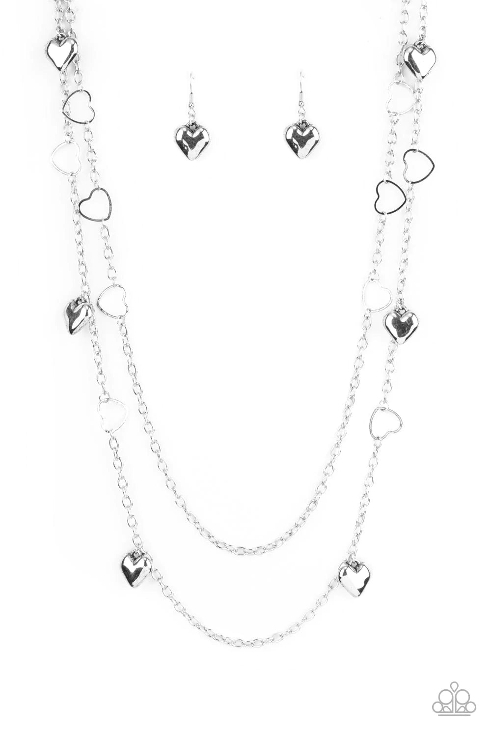 Paparazzi Accessories Chicly Cupid - Silver Airy silver heart frames delicately link with sections of classic silver chains across the chest, creating flirtatious layers. Solid silver heart charms whimsically swing from the display, reminiscent of vintage