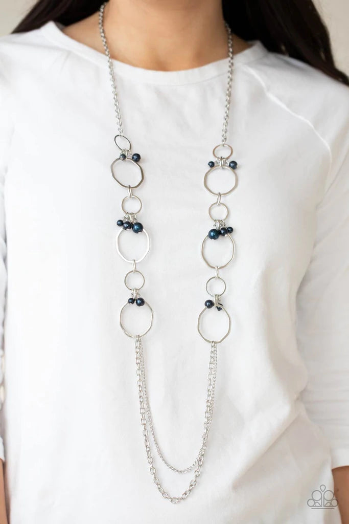 Paparazzi Accessories Ante UPSCALE - Blue Oversized bent silver hoops accented with Montana Blue pearl charms link together for a refined upscale design. A set of mismatched chains at the end of the lengthened necklace adds balance. Features an adjustable