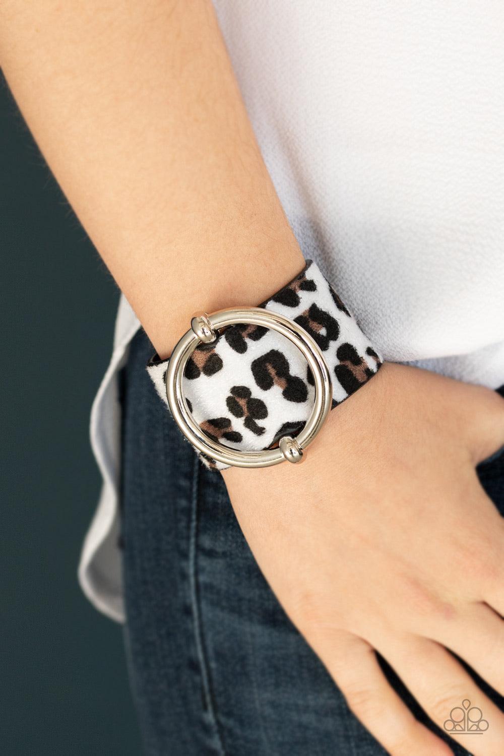 Paparazzi Accessories Asking FUR Trouble - White A dramatically oversized silver ring slides along a thick black leather band featuring fuzzy white cheetah print for a wild finish. Features an adjustable snap closure. Jewelry