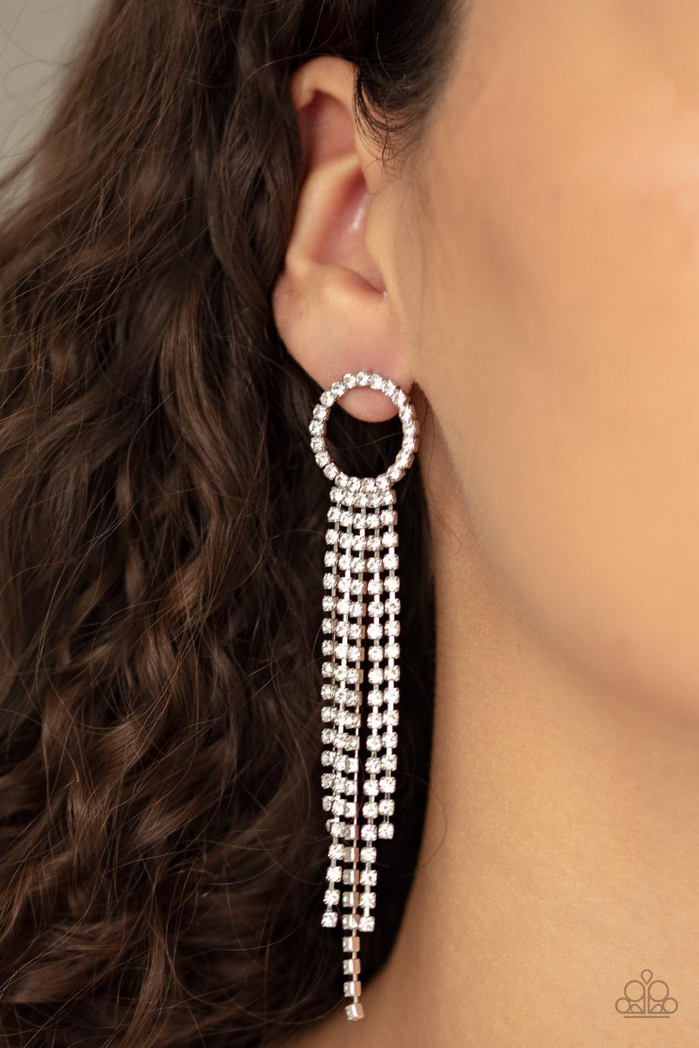 Paparazzi Accessories Endless Sheen - White Infused with sleek silver fittings, strands of glittery white rhinestones cascade from the bottom of a white rhinestone encrusted hoop, creating an elegantly tapered fringe. Earring attaches to a standard post f