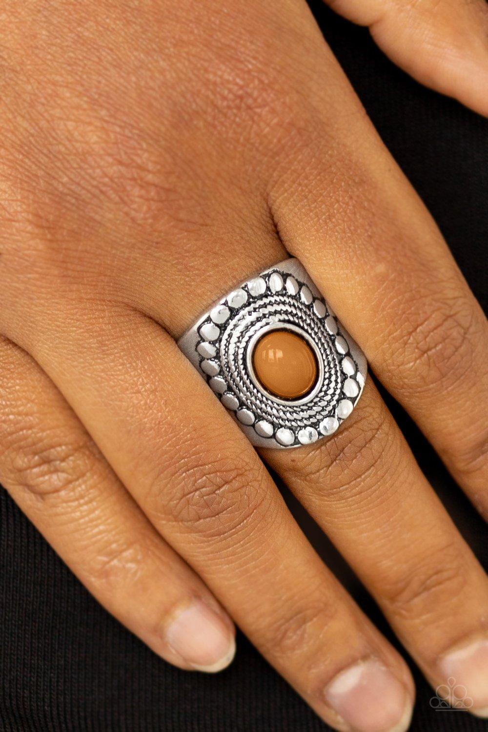 Paparazzi Accessories Zen To One - Brown A shiny Meerkat bead is pressed into the center of a thick band radiating with dotted and rope-like patterns for a seasonal look. Features a stretchy band for a flexible fit. Sold as one individual ring. Jewelry