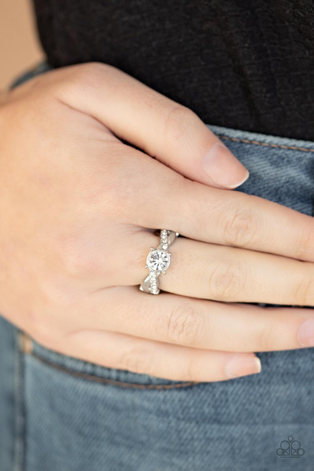 Paparazzi Accessories Prim And Proper - White A plain silver and white rhinestone encrusted silver band delicately braid across the finger. A classic white rhinestone adorns the center, creating a timeless centerpiece. Features a dainty stretchy band for