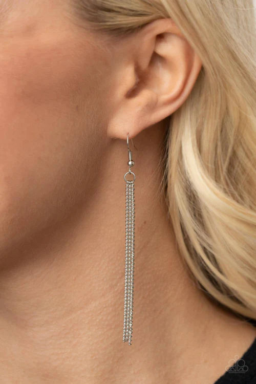 Paparazzi Accessories Radical Refinery - Red An oversized concave silver disc, ribbed with linear texture, creates a dramatic backdrop for a vertical row of faceted red beads. A flirty tassel of delicate silver chains sways from the bottom of the pendant