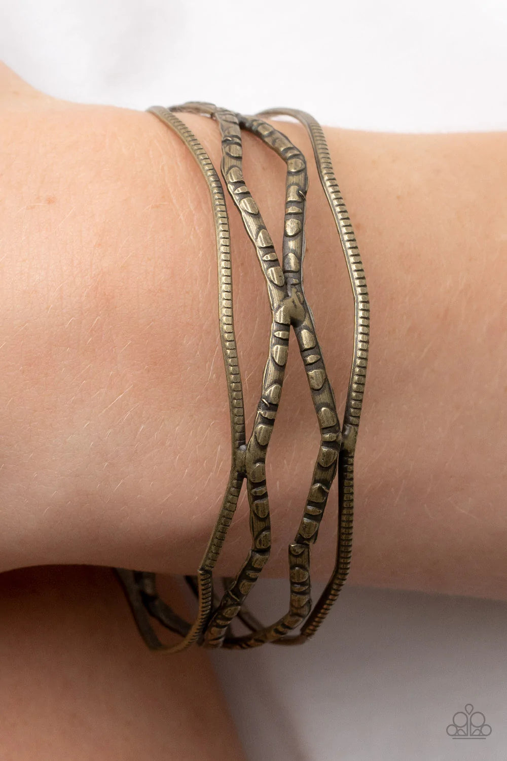 Paparazzi Accessories A Narrow ESCAPADE - Brass Textured and embossed in nature inspired patterns, rustic brass bars zigzag around the wrist as they stack into a wildly layered bangle. Sold as one individual bracelet. Jewelry