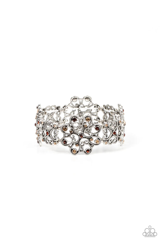 Paparazzi Accessories Regal Recognition - Brown Dainty topaz and golden topaz rhinestones scatter across the fronts of airy medallions fashioned from whimsical heart-shaped filigree. The splendid frames alternate along stretchy bands resulting in a regall