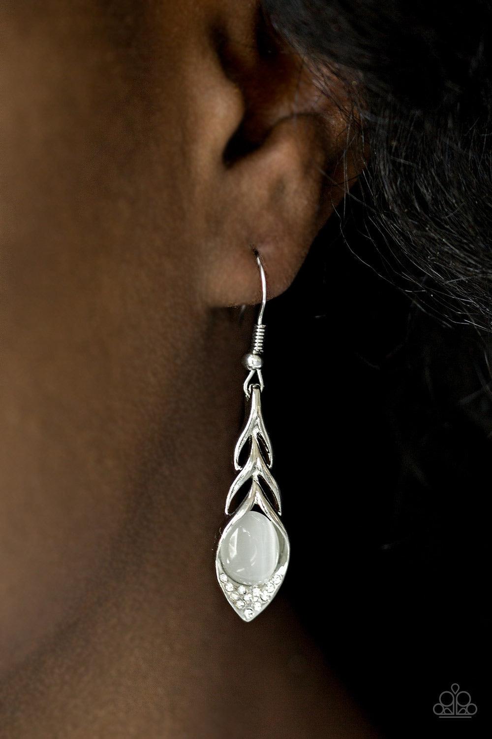 Paparazzi Accessories Soaring Shimmer - White A glowing white moonstone is nestled in the bottom of a feather-like frame, creating a whimsical lure. Earring attaches to a standard fishhook fitting. Jewelry