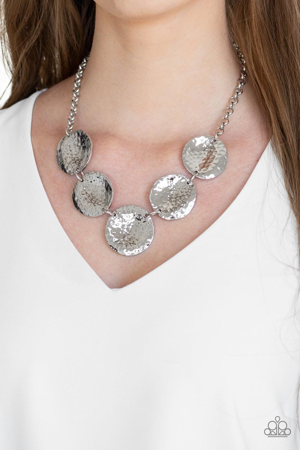 Paparazzi Accessories First Impressions - Silver Featuring a hammered high-sheen finish, imperfect round silver frames link below the collar for a casual look. Features an adjustable clasp closure. Sold as one individual necklace. Includes one pair of mat