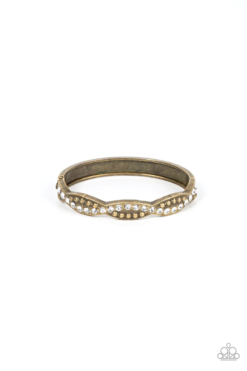 Paparazzi Accessories Empire Envy - Brass Ribbons of antiqued brass studs and glassy white rhinestones delicately intertwines across the front of a scalloped bangle-like bracelet, resulting in an edgy sparkle around the wrist. Jewelry