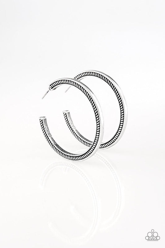 Paparazzi Accessories This is My Tribe - Silver Radiating with tactile textures, a glistening silver hoop curls around the ear for a tribal inspired look. Earring attaches to a standard post fitting. Hoop measures 2" in diameter. Jewelry