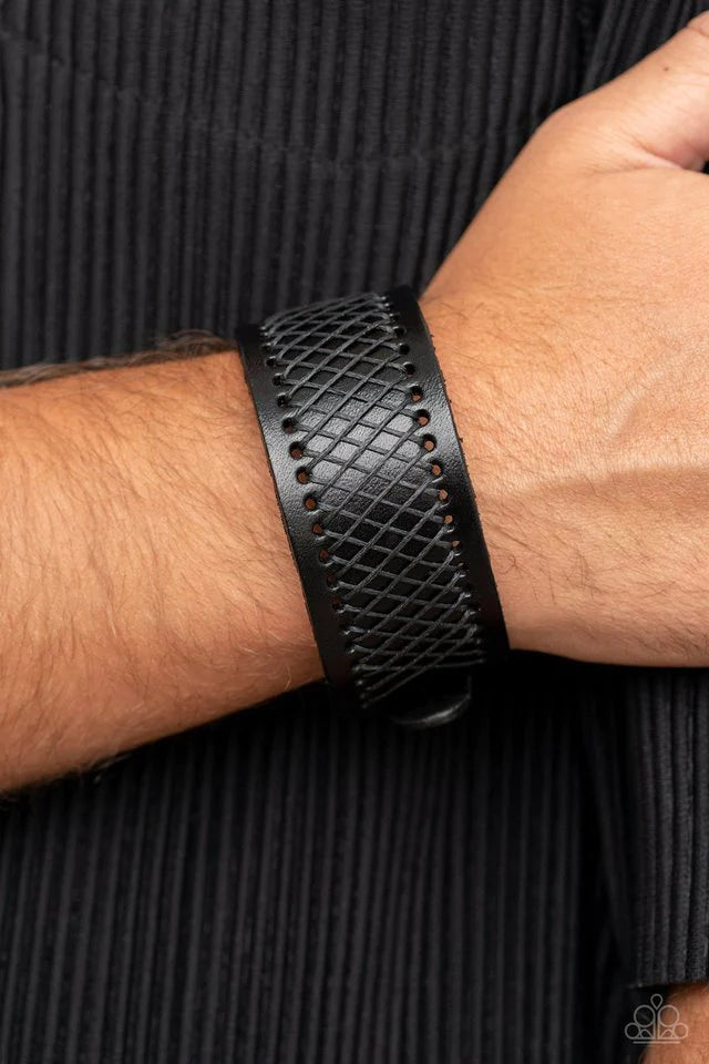 Paparazzi Accessories Drifter Discovery - Black Shiny black cording boldly crisscrosses across the front of a thick black leather band, creating an edgy centerpiece around the wrist. Features a buckle closure. Jewelry