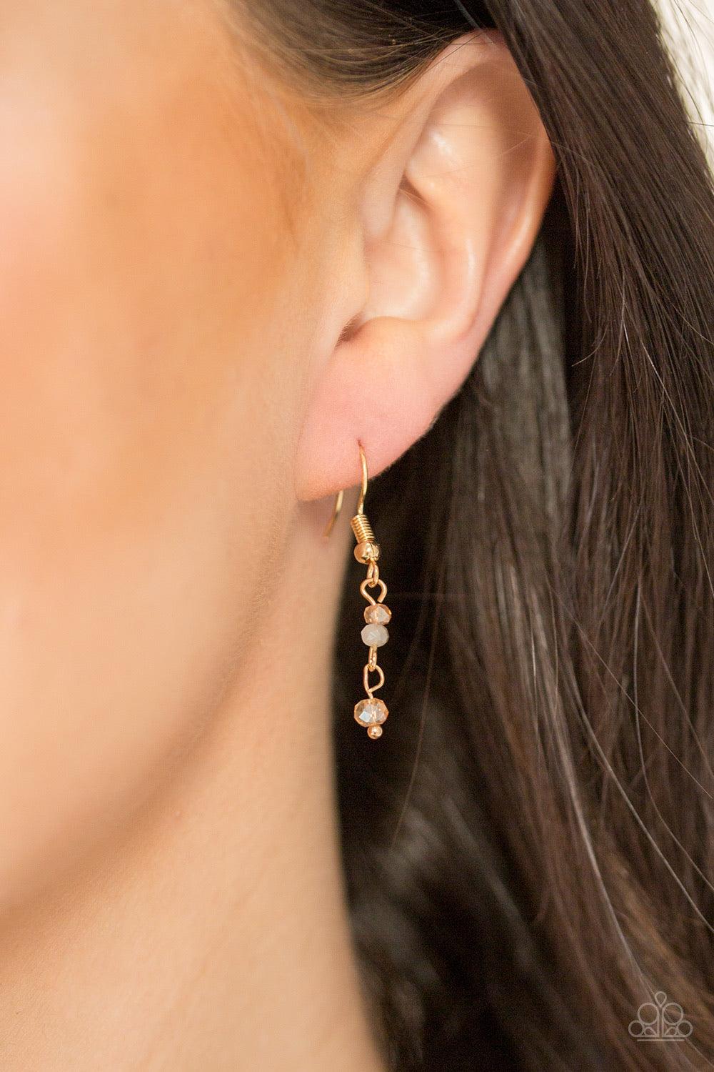 Paparazzi Accessories Twilight Twinkle ~Multi Twinkling gold beads are threaded along dainty gold rods, creating a sparkling fringe at the bottom of a lengthened gold chain. A lobster clasp hangs from the bottom of the design to allow a name badge or othe
