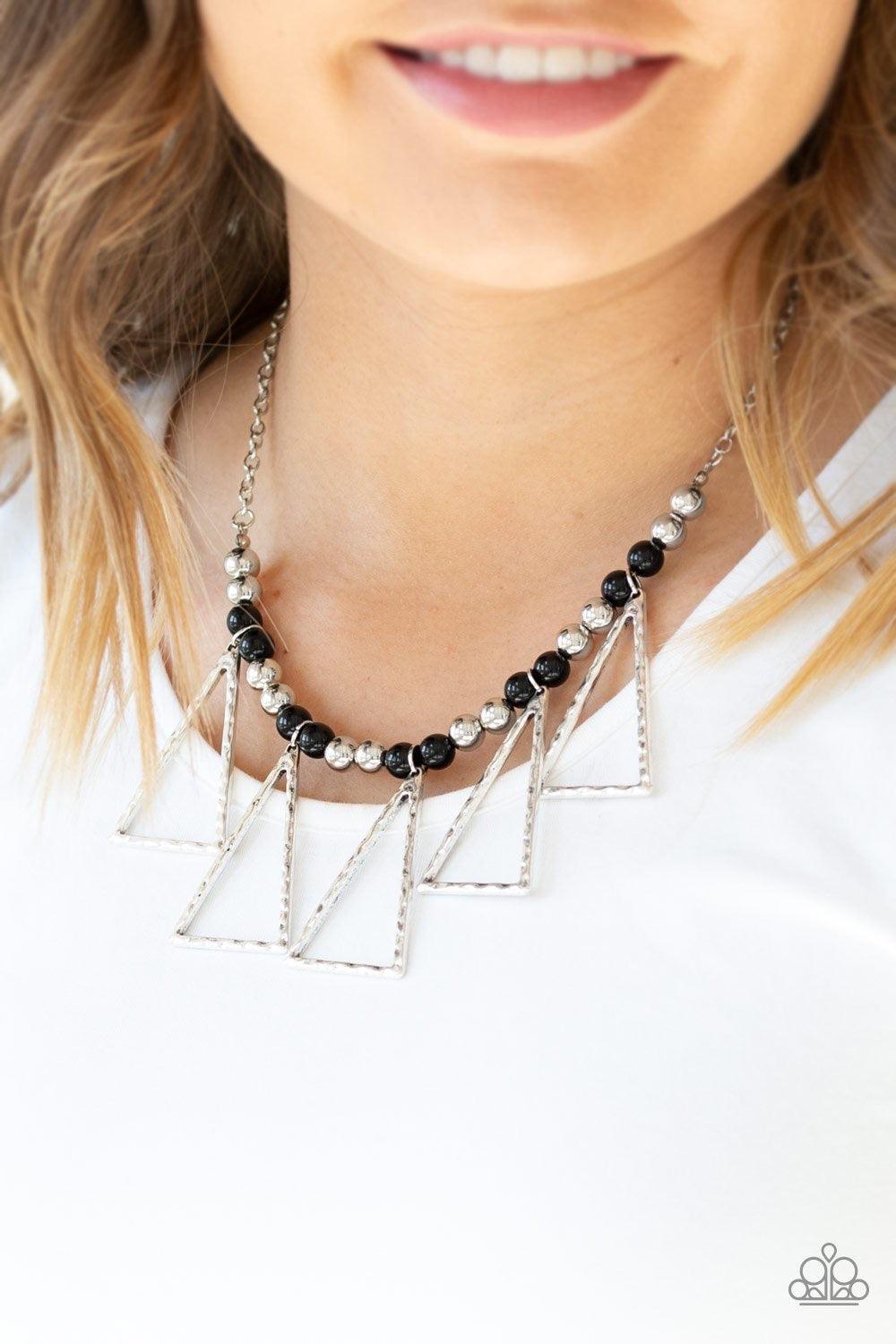 Paparazzi Accessories Terra Nouveau - Black A collection of shiny silver and shiny black beads are threaded along an invisible wire below the collar. Hammered triangular frames swing from the bottom of the colorful compilation, creating an artistic fringe