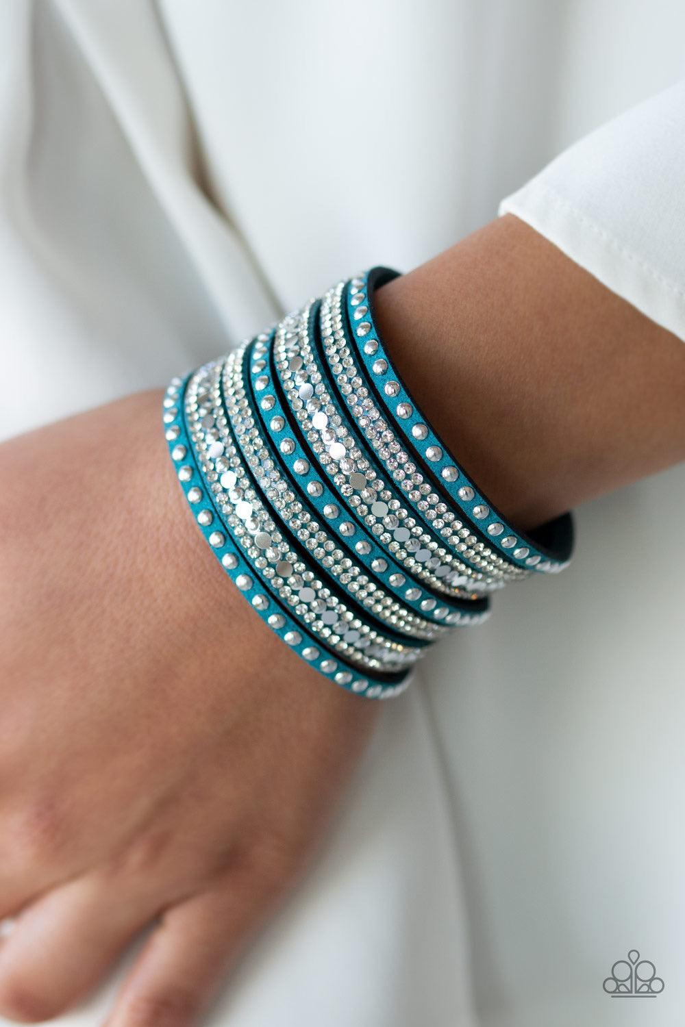 Paparazzi Accessories All Hustle and Hairspray - Blue A thick blue suede band has been spliced into glittery strands encrusted in a collection of dainty silver studs, glittery white rhinestones, and flat silver discs for a sassy look. Features an adjustab