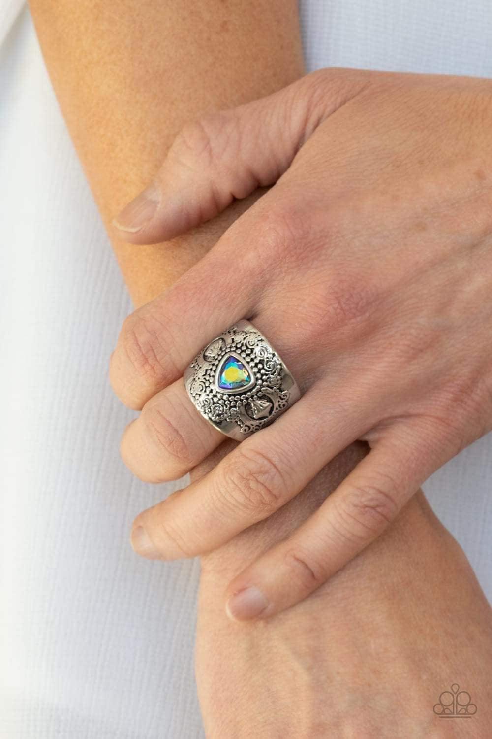 Paparazzi Accessories Magic Maker - Green Featuring an iridescent shimmer, a triangular green rhinestone is pressed into the center of a thick silver band embossed in whimsically studded patterns for an enchanted finish. Features a stretchy band for a fle