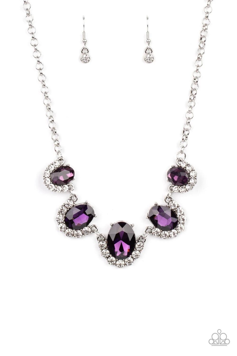 Paparazzi Accessories The Queen Demands It - Purple Gradually increasing in size at the center, the sparkly bottoms of oversized purple gems are bordered in rows of glassy white rhinestones as they link below the collar for a dramatic effect. Features an