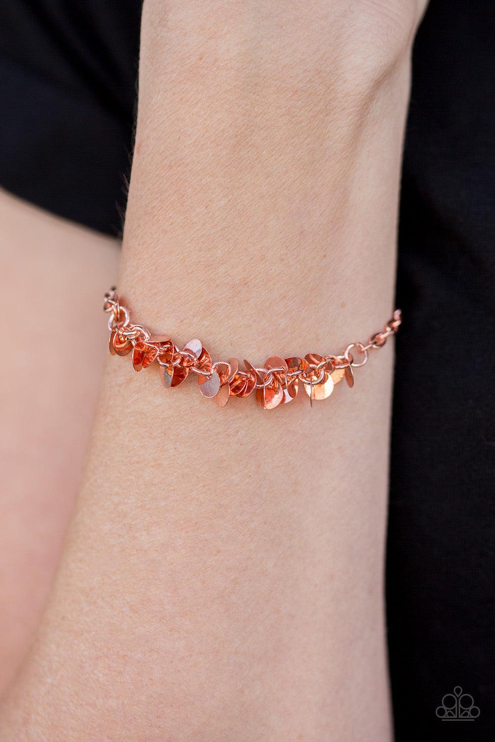 Paparazzi Accessories Shimmer Train - Copper Dainty shiny copper discs trickle along the wrist, creating a flirty fringe. The flat shiny discs catch and reflect the light, creating playful movement across the skin. Features an adjustable clasp closure. Je