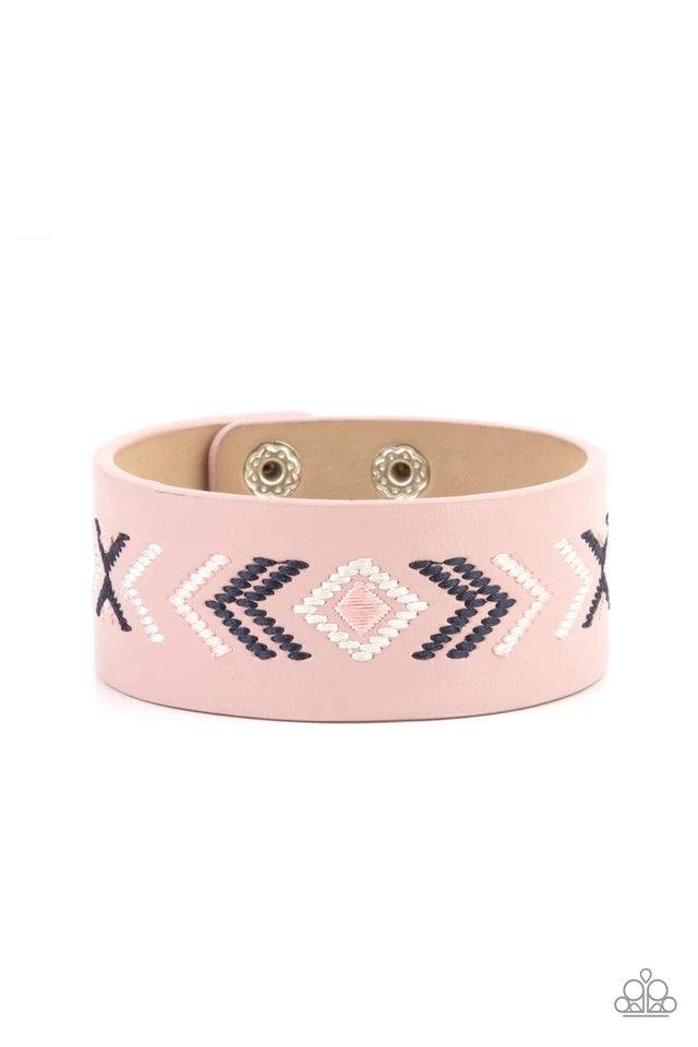 Paparazzi Accessories Cliff Glyphs - Pink Pink, blue, and white thread is stitched across the front of a pink leather band, creating a colorful tribal inspired pattern. Features an adjustable snap closure. Jewelry