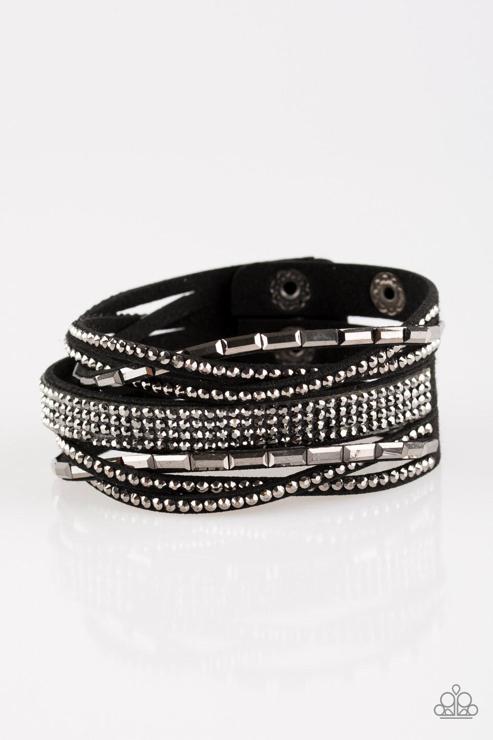 Paparazzi Accessories Tough Girl Glamour - Black Featuring edgy emerald and classic style cuts, glittery hematite rhinestones are encrusted along crisscrossing strands of black suede for a fierce one-of-a-kind look. Features an adjustable snap closure. Je